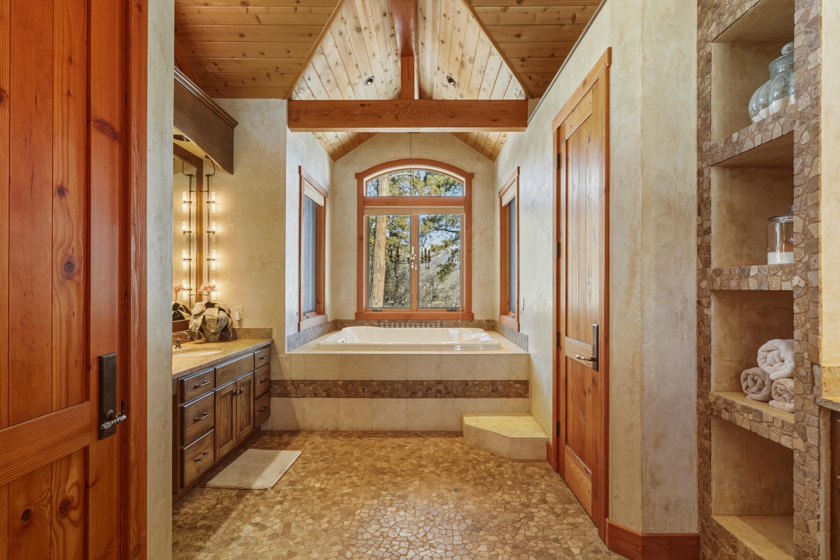 Primary bath with jacuzzi and stone tiling